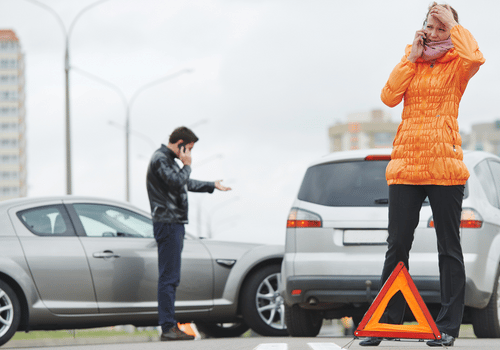 car accident lawyers Carrollton Georgia Smith Wallis and Scott - Image of two adults on their phones in front of two grey cars