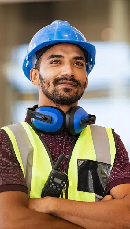 Construction worker with blue hard hat and blue ear muffs who may benefit from the help of Workers Compensation Lawyers in Carrollton, GA